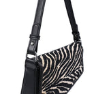 Urban Expressions Tuesday Fatima zebra shoulder bag with black leather strap and textured zebra print fabric.