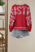 Mello Tuesday Holiday Merry Christmas letter sweatshirt featuring festive red and white design, cozy knit fabric, and holiday lettering.