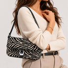 Urban Expressions Tuesday Gloria zebra shoulder bag with black strap and textured zebra print fabric.