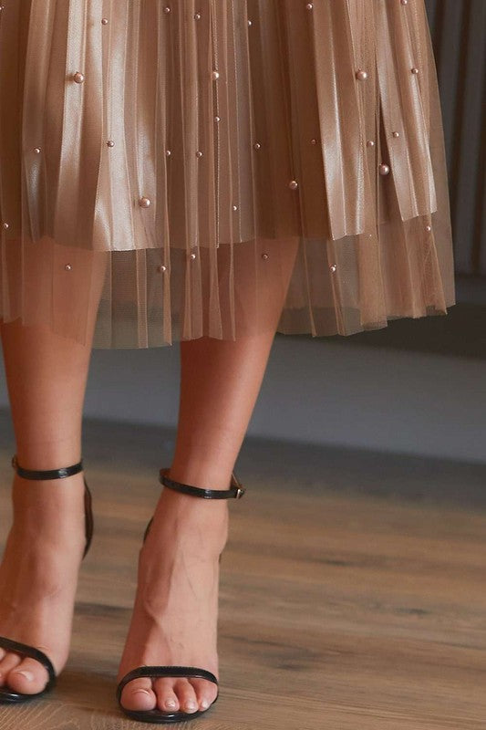 Pearl-embellished pleated mesh midi skirt by RARA Boutique, featuring a flowing design with pearl accents on a sheer mesh fabric.